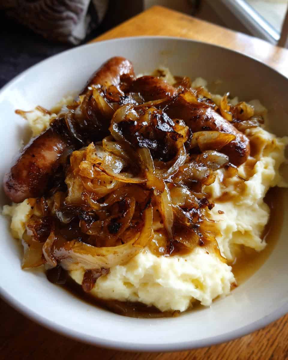 Saftige Bratwürste auf cremigem Püree mit karamellisierten Zwiebeln - detail 2